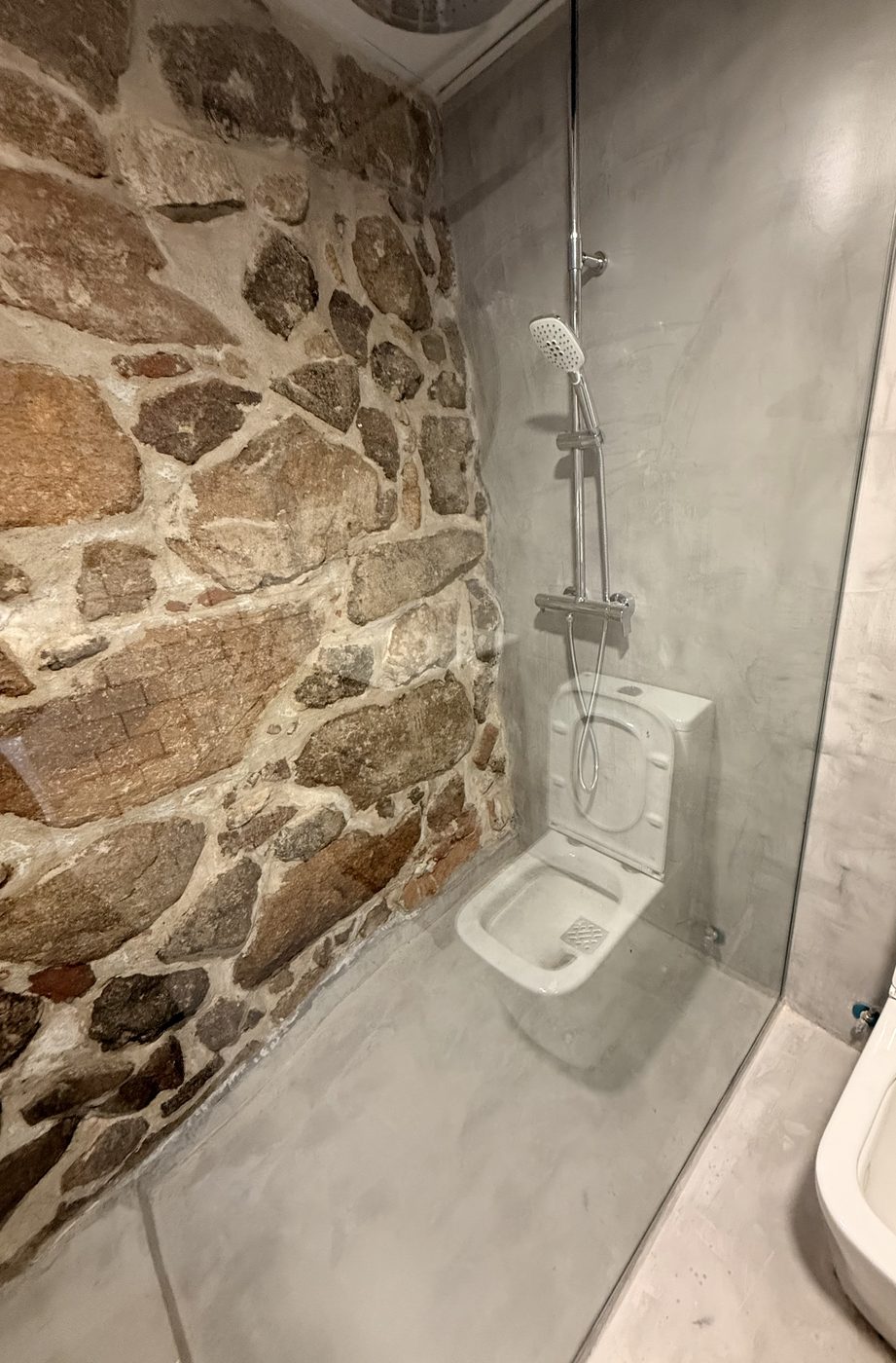 Ducha de obra con microcemento y piedra rústica